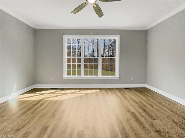 spare room with baseboards, ceiling fan, and crown molding