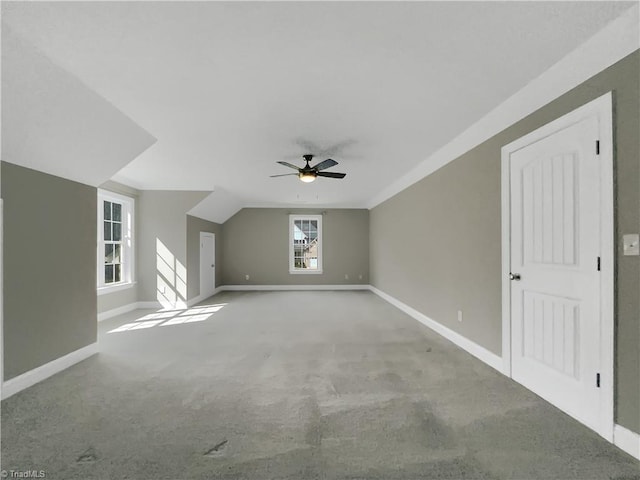 bonus room with lofted ceiling, carpet flooring, a ceiling fan, and baseboards