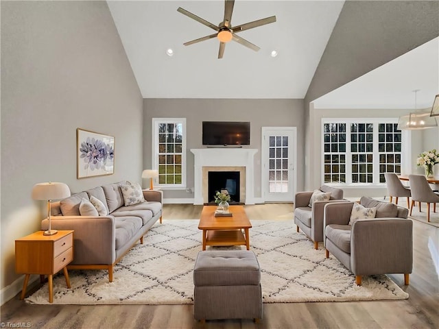 living room with wood finished floors, high vaulted ceiling, recessed lighting, a fireplace, and ceiling fan