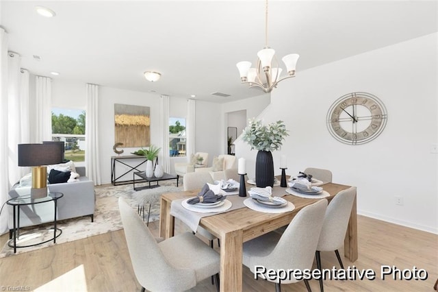 dining area featuring a notable chandelier and light wood-type flooring