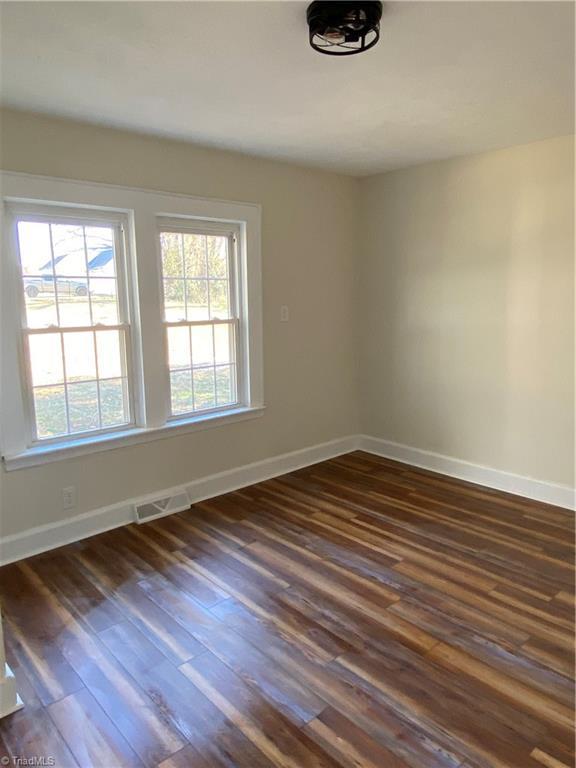 spare room with dark wood-type flooring