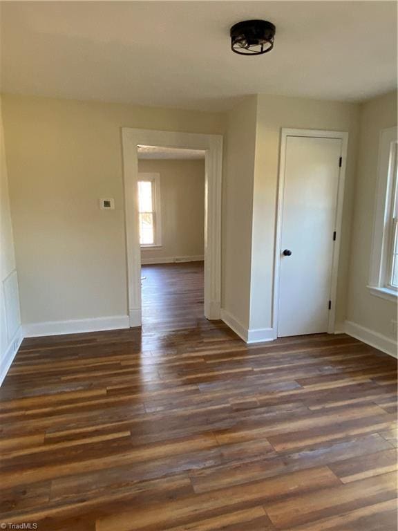 unfurnished room with plenty of natural light and dark hardwood / wood-style floors