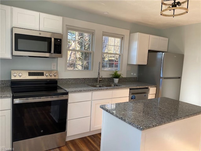 kitchen with sink, white cabinetry, dark hardwood / wood-style floors, a kitchen island, and stainless steel appliances