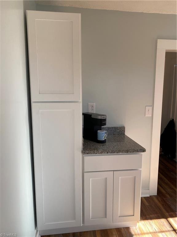 kitchen with dark hardwood / wood-style floors, white cabinets, and dark stone counters