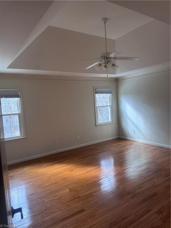 spare room featuring wood finished floors, a wealth of natural light, and ceiling fan