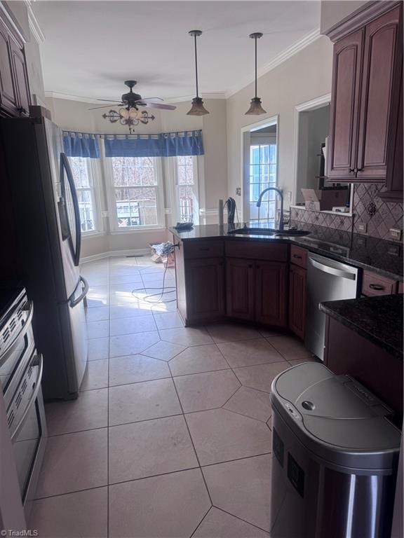 kitchen featuring ornamental molding, a sink, tasteful backsplash, stainless steel appliances, and a peninsula