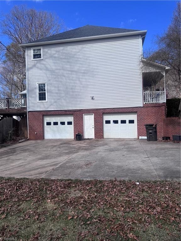 view of property exterior with central air condition unit, brick siding, and an attached garage