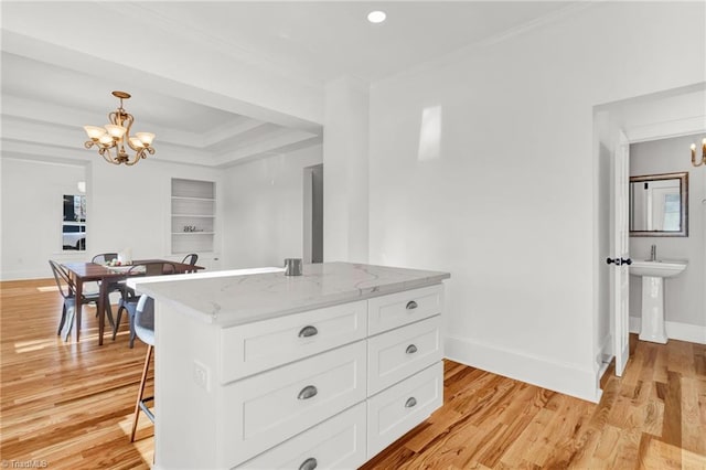 kitchen with pendant lighting, light stone countertops, a notable chandelier, light hardwood / wood-style floors, and white cabinetry