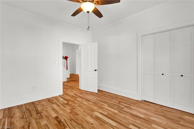 unfurnished bedroom featuring ceiling fan, light hardwood / wood-style floors, ornamental molding, and a closet