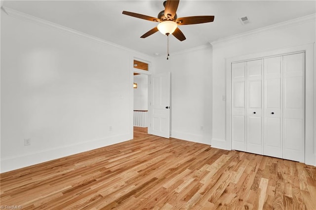 unfurnished bedroom featuring ceiling fan, light hardwood / wood-style floors, ornamental molding, and a closet