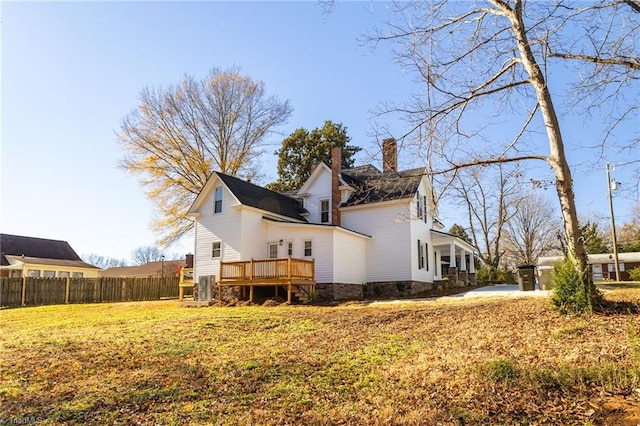 back of property featuring a lawn and a deck