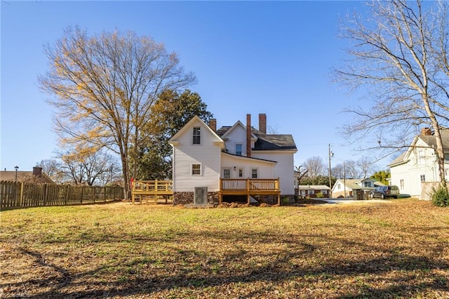 rear view of house with a yard and a wooden deck