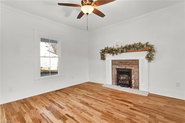 unfurnished living room with hardwood / wood-style flooring, ceiling fan, crown molding, and a brick fireplace