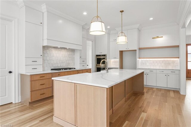 kitchen with light wood finished floors, crown molding, stainless steel appliances, white cabinetry, and open shelves