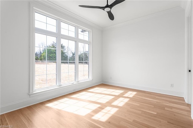 unfurnished room with a ceiling fan, crown molding, light wood-style floors, and baseboards