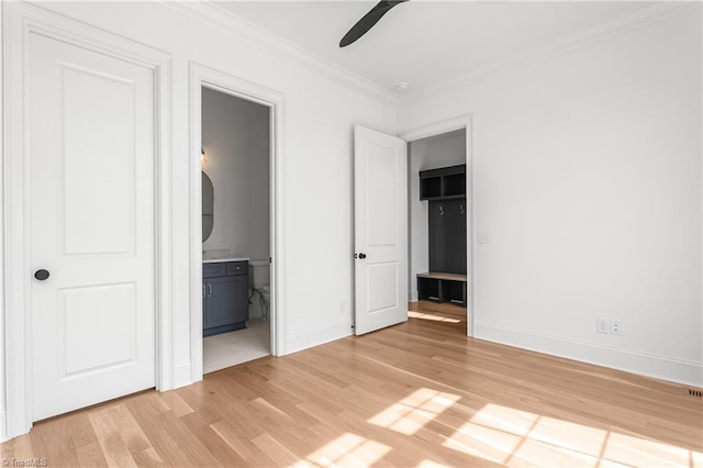 unfurnished bedroom featuring light wood-style flooring, connected bathroom, baseboards, and ornamental molding