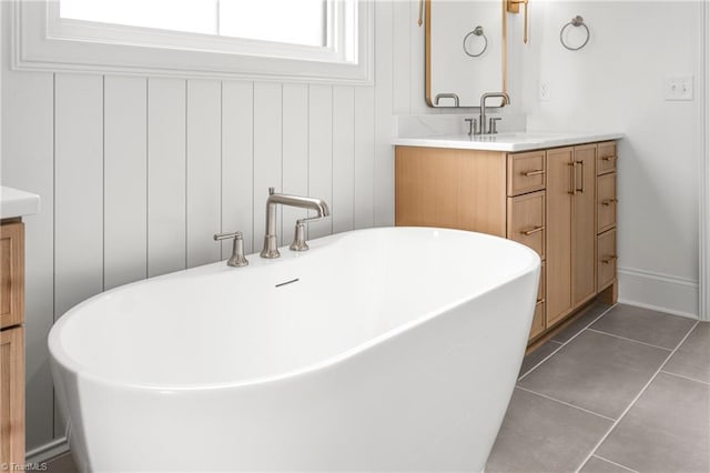 full bath with tile patterned floors, a soaking tub, and vanity