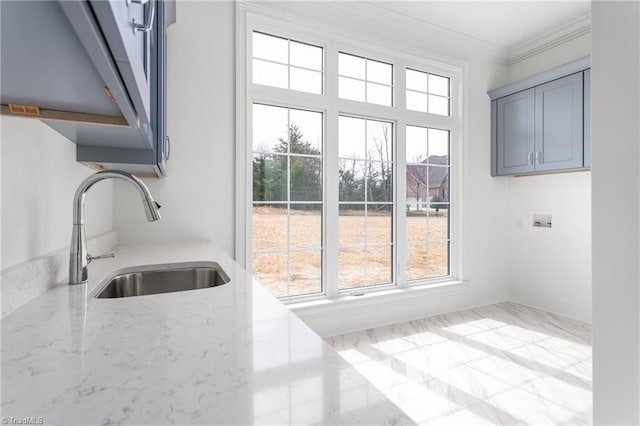 kitchen featuring light stone countertops, baseboards, a sink, crown molding, and marble finish floor