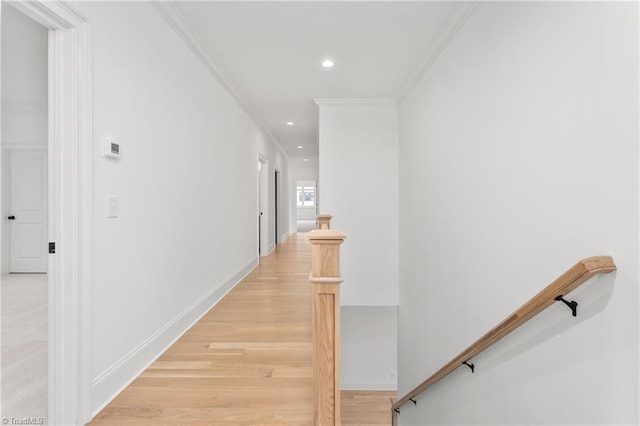 hallway with an upstairs landing, recessed lighting, light wood-style floors, crown molding, and baseboards