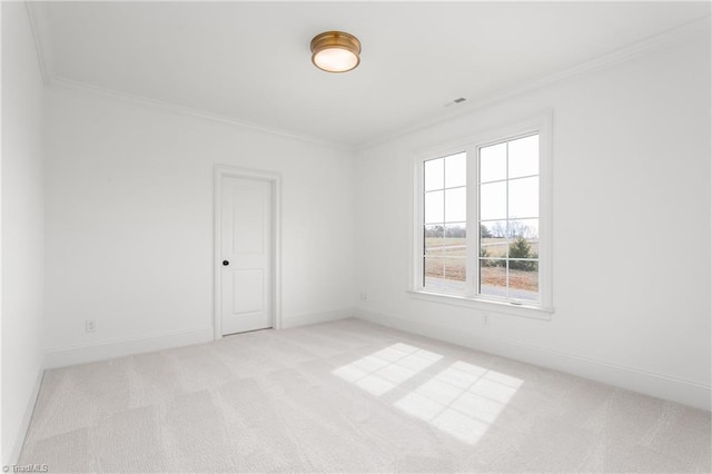 spare room with crown molding, light colored carpet, and baseboards
