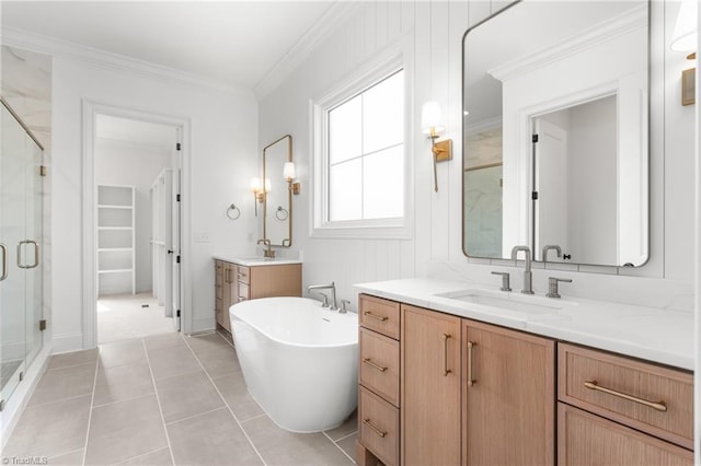 full bathroom featuring two vanities, ornamental molding, a sink, a shower stall, and a soaking tub