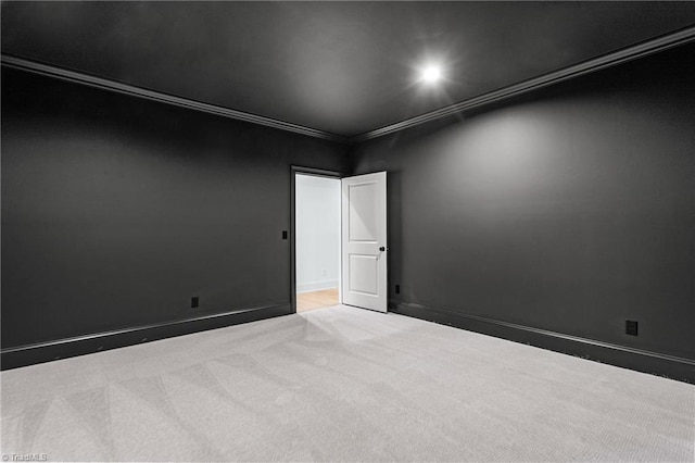 carpeted empty room featuring baseboards and ornamental molding