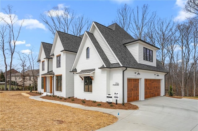 view of property exterior featuring an attached garage, brick siding, driveway, and a shingled roof