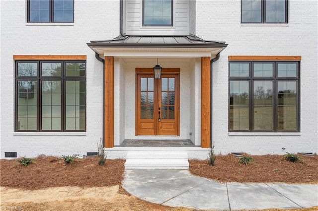 property entrance featuring crawl space, stucco siding, metal roof, and a standing seam roof