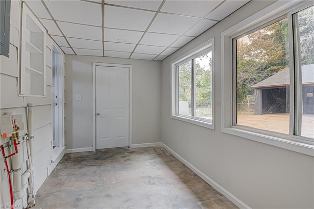 spare room with a paneled ceiling and concrete flooring