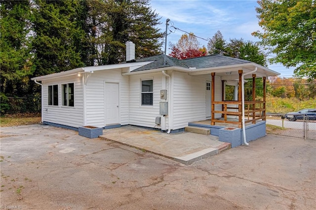 rear view of property featuring covered porch