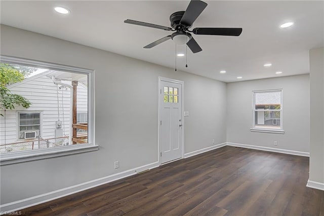 empty room featuring dark hardwood / wood-style floors, ceiling fan, and cooling unit