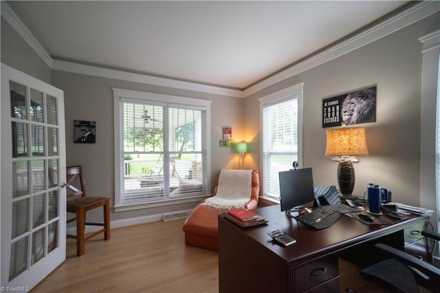 home office with crown molding and light hardwood / wood-style flooring