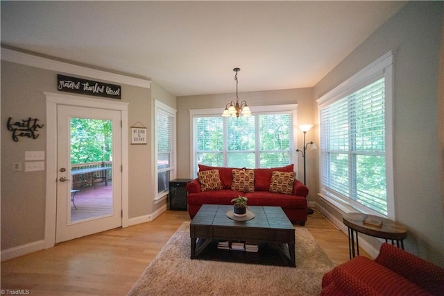 living room with a chandelier, light hardwood / wood-style floors, and plenty of natural light