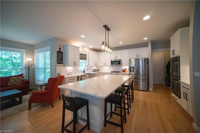 kitchen with white cabinets, pendant lighting, and appliances with stainless steel finishes