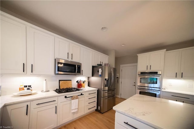 kitchen featuring white cabinets, appliances with stainless steel finishes, and light hardwood / wood-style floors