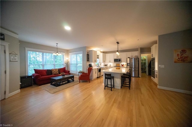 living room featuring sink, a chandelier, and light wood-type flooring