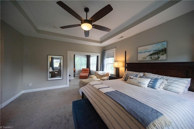 carpeted bedroom featuring a raised ceiling, ceiling fan, and ornamental molding