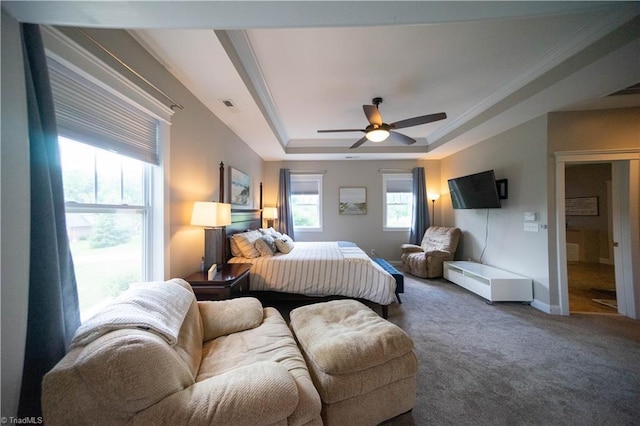 carpeted bedroom with a raised ceiling, ceiling fan, and ornamental molding