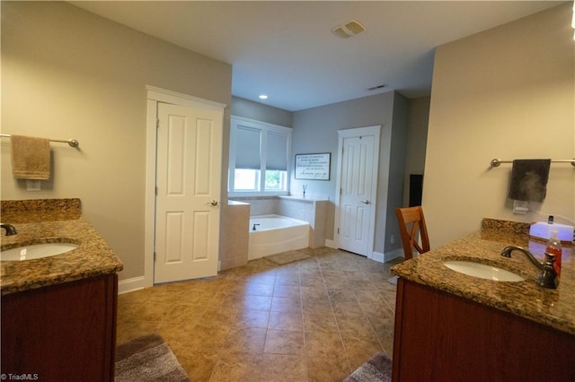 bathroom featuring a tub to relax in, tile patterned flooring, and vanity