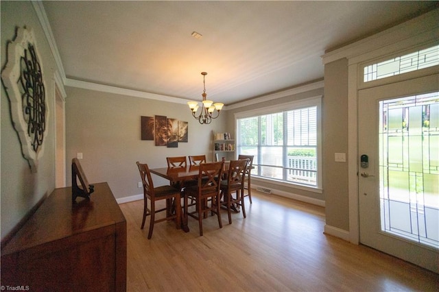 dining area with light hardwood / wood-style flooring, a notable chandelier, and ornamental molding