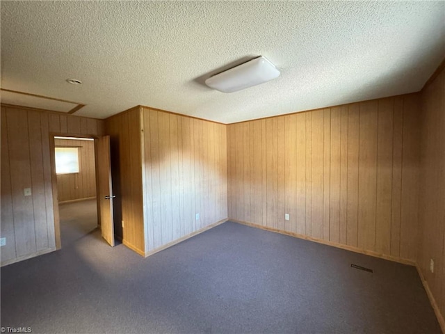 unfurnished room with visible vents, carpet floors, and a textured ceiling