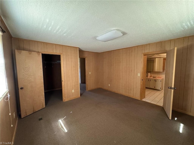 unfurnished bedroom featuring a closet, carpet floors, and a textured ceiling