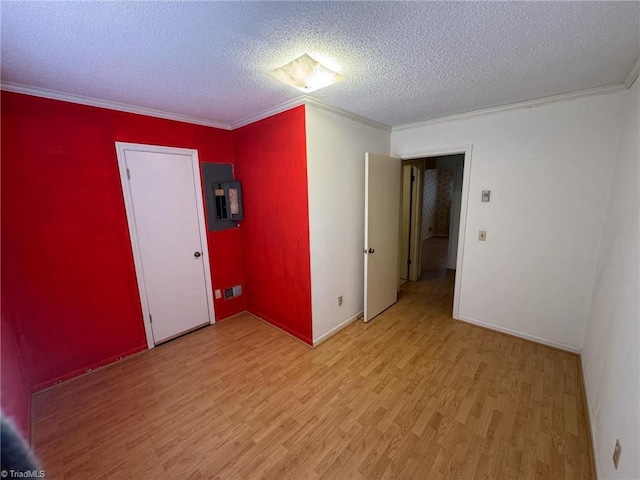 empty room with crown molding, electric panel, light wood finished floors, and a textured ceiling