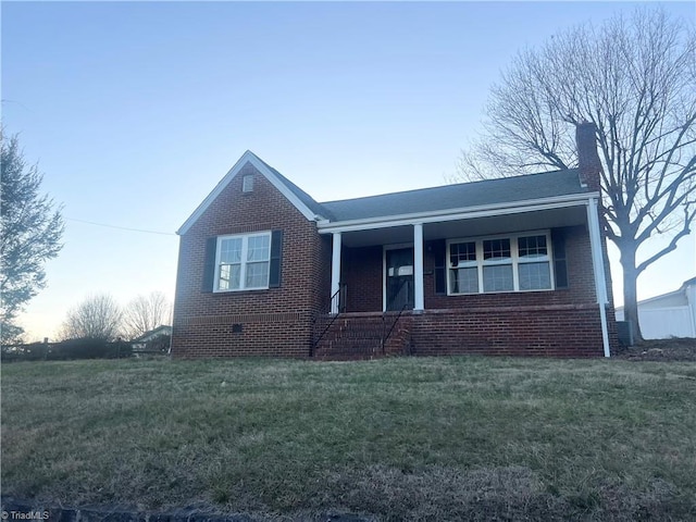 ranch-style home with brick siding, a chimney, and a front yard