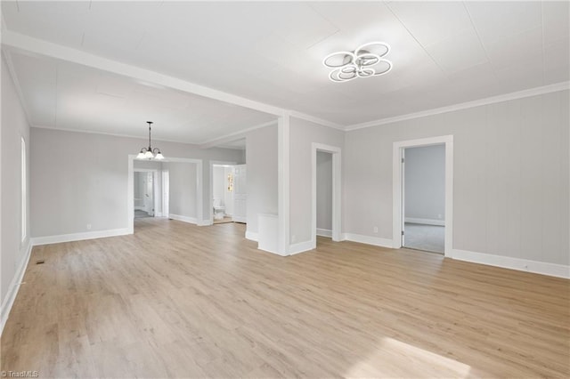 unfurnished living room featuring an inviting chandelier, light hardwood / wood-style flooring, and ornamental molding