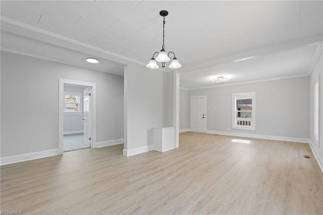 spare room featuring a chandelier, crown molding, and light hardwood / wood-style flooring