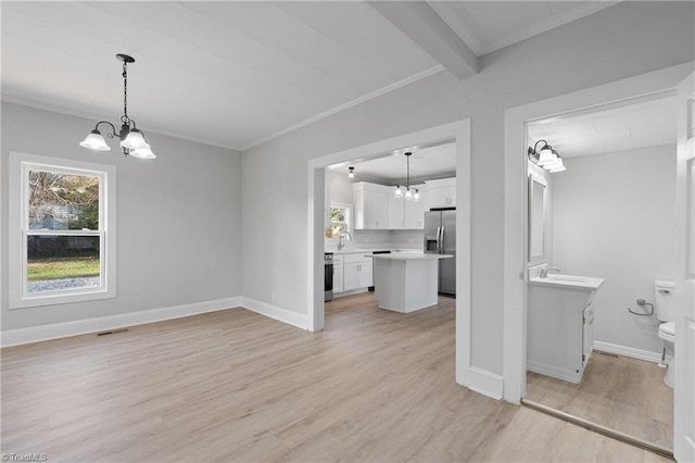 unfurnished living room with beam ceiling, crown molding, light hardwood / wood-style flooring, and a chandelier