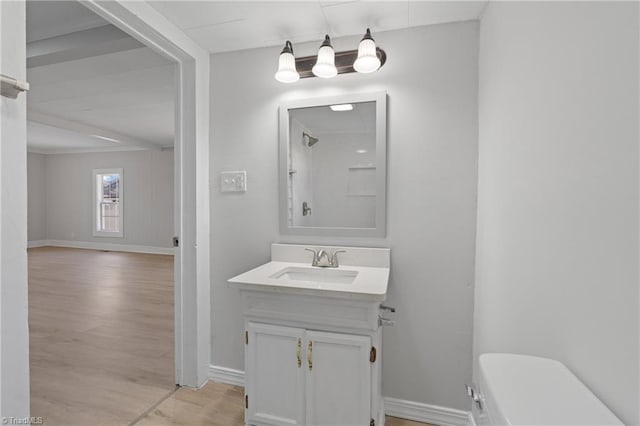 bathroom with hardwood / wood-style floors, vanity, and toilet