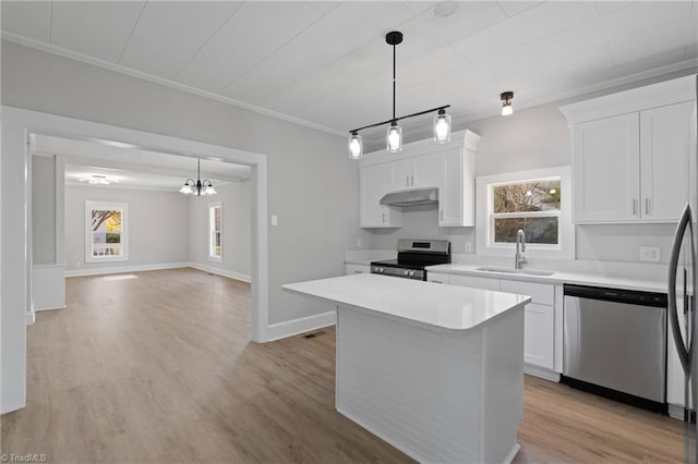 kitchen featuring white cabinets, a kitchen island, stainless steel appliances, and hanging light fixtures