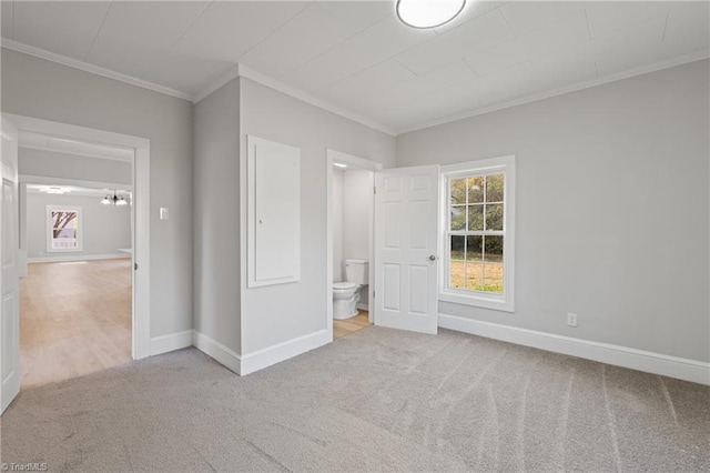 unfurnished bedroom with ensuite bathroom, ornamental molding, and light carpet